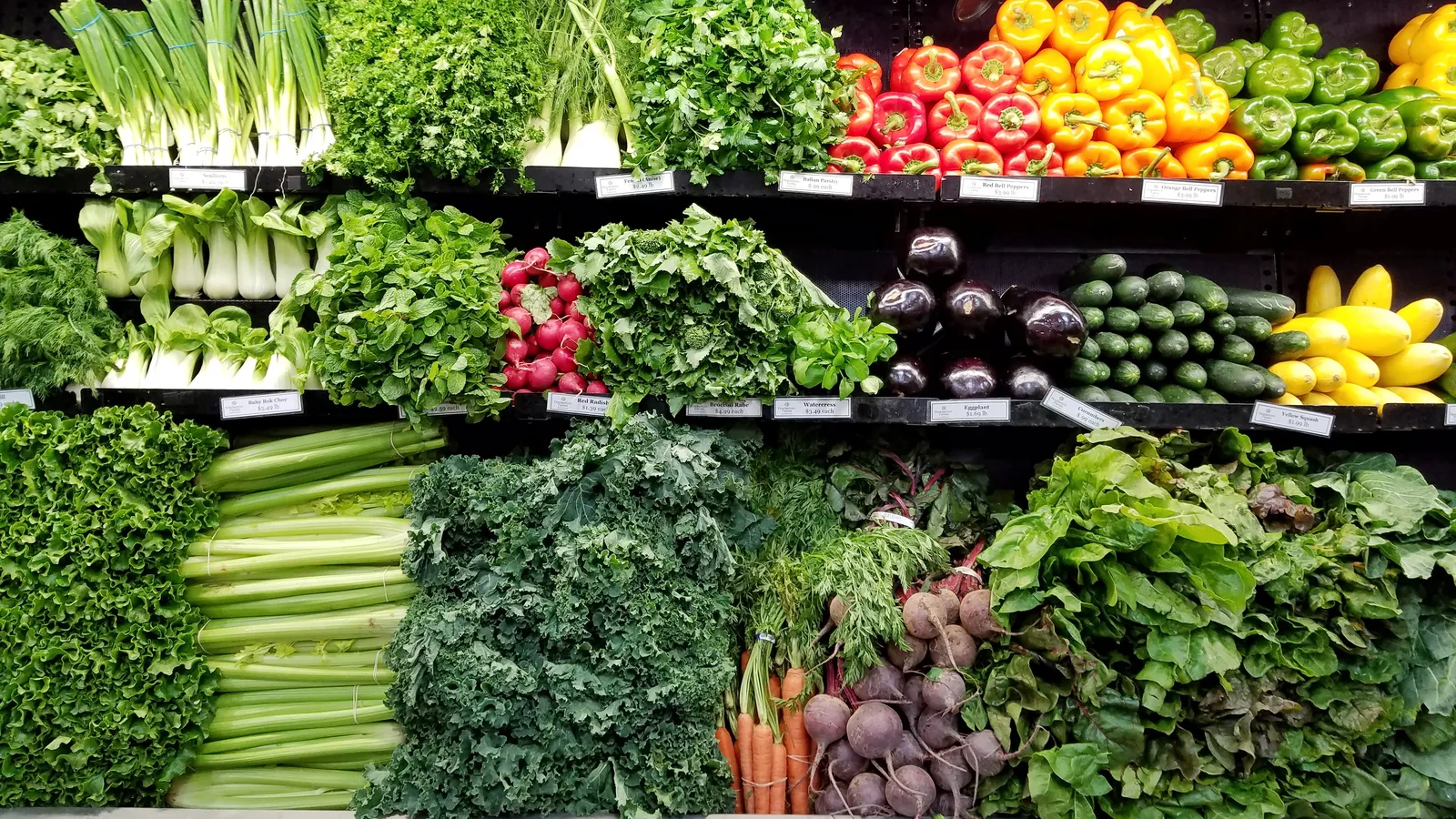 Shelves of fresh leafy greens, peppers and root vegetables, representing everyday food choices that help lower blood sugar